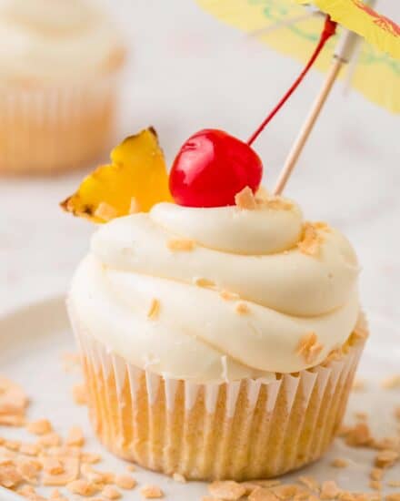 These piña colada cupcakes are the perfect blend of fluffy, soft, and moist. Topped with a swirl of vanilla buttercream frosting, and garnished with pineapple and a maraschino cherry, they taste like a sweet and coconut-y piña colada cocktail, and are perfect for Spring and Summer!