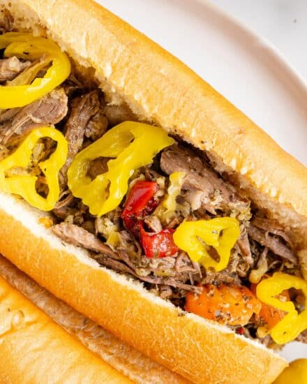 Deliciously tangy and piquant, this slow cooker Italian beef is made easily with simple ingredients and cooks all day, so it's ready when you get home! Perfect on sandwiches, sliders, or over mashed potatoes, this recipe is pure comfort food.