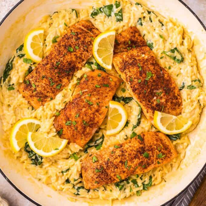 overhead photo of salmon over creamy orzo with lemon and spinach.