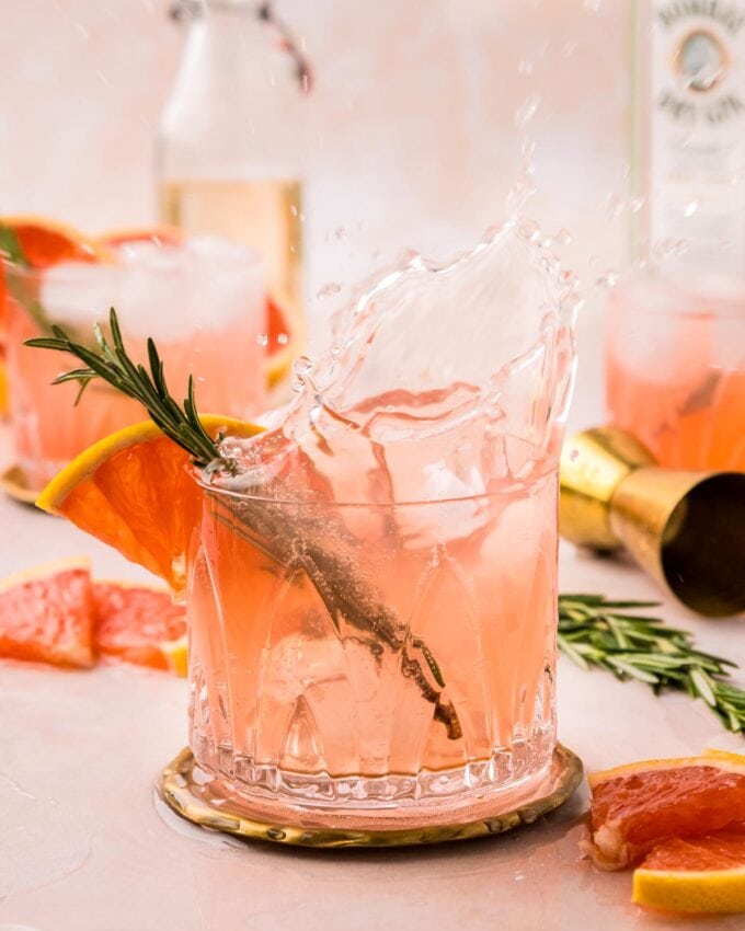 an ice cube dropped into a gin fizz cocktail creates a splash.