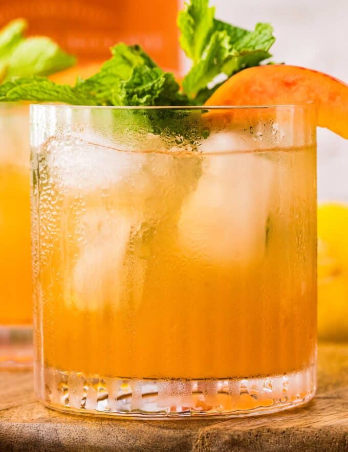 This cocktail is the perfect blend of sweet and tart, with an earthy bourbon kick! The peaches add an amazing sweetness, and the cinnamon peach syrup is great to make ahead. Single serving and large batch recipes included!