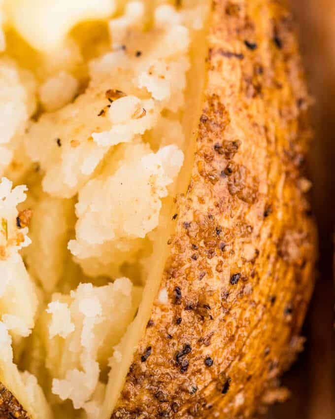 close up photo of the seasoned skin and fluffy inside of a smoked baked potato