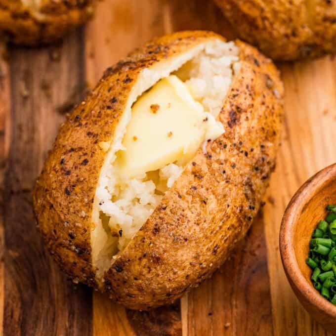 smoked baked potatoes served with butter and chives.