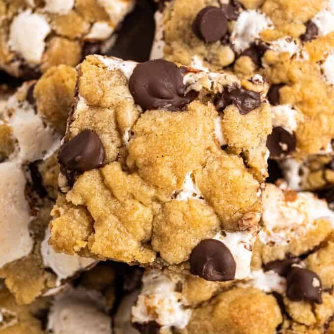 s'mores chocolate chip cookie bars stacked on a plate.