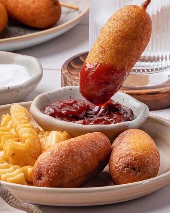 dipping a corn dog into chipotle ketchup.