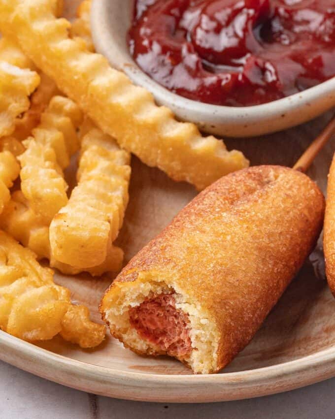 mini corn dog with a bite taken out of it.