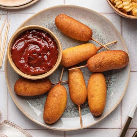 grey plate with mini corn dogs with a small bowl of chipotle ketchup