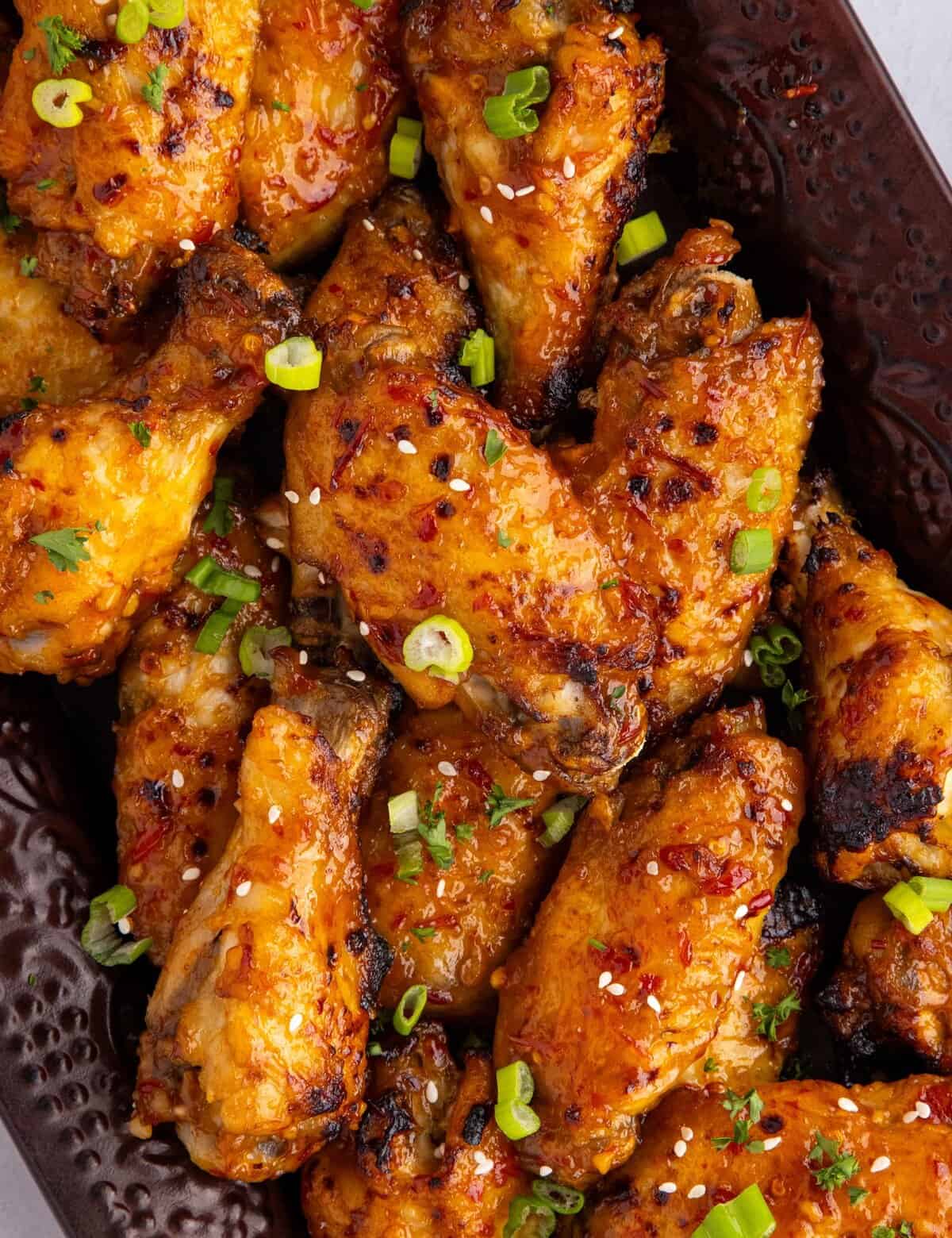 This recipe for juicy and crispy baked chicken wings uses a simple marinade and homemade sweet chili sauce, and a cooking method that yields some of the best wings you’ll have! Perfect for game day tailgates, parties, and more!