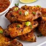 baked chicken wings piled on a white platter.