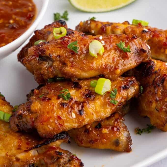 baked chicken wings piled on a white platter.
