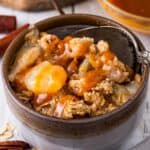 pear crisp in gray and brown bowl with caramel sauce