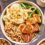 overhead photo of salmon grain bowl with a fork