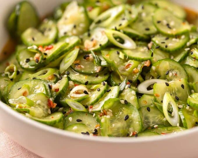 close up photo of asian cucumber salad in a white bowl