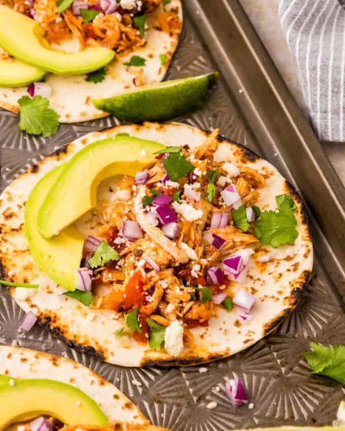 taco with chicken tinga filling and toppings on a sheet pan