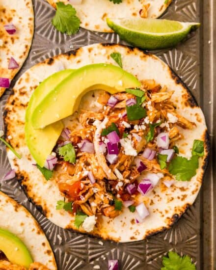 These easy chicken tinga tacos are made with tender and juicy shredded chicken that's simmered in a bold and smoky chipotle sauce! The chicken is perfect in tacos, burritos, enchiladas, nachos, and more!