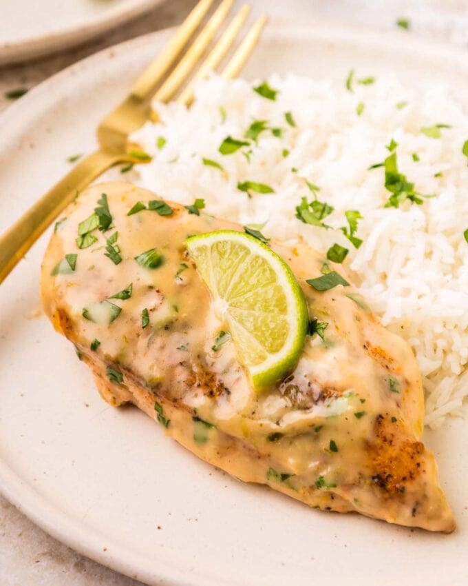 coconut lime chicken breast on a white plate with rice