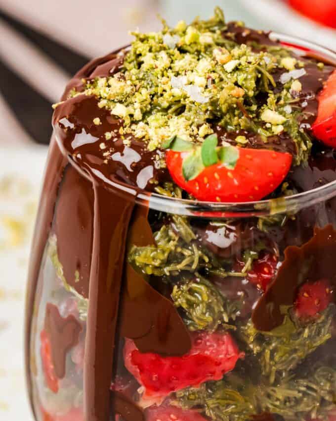 chocolate drizzled over dubai chocolate strawberries in a wine glass