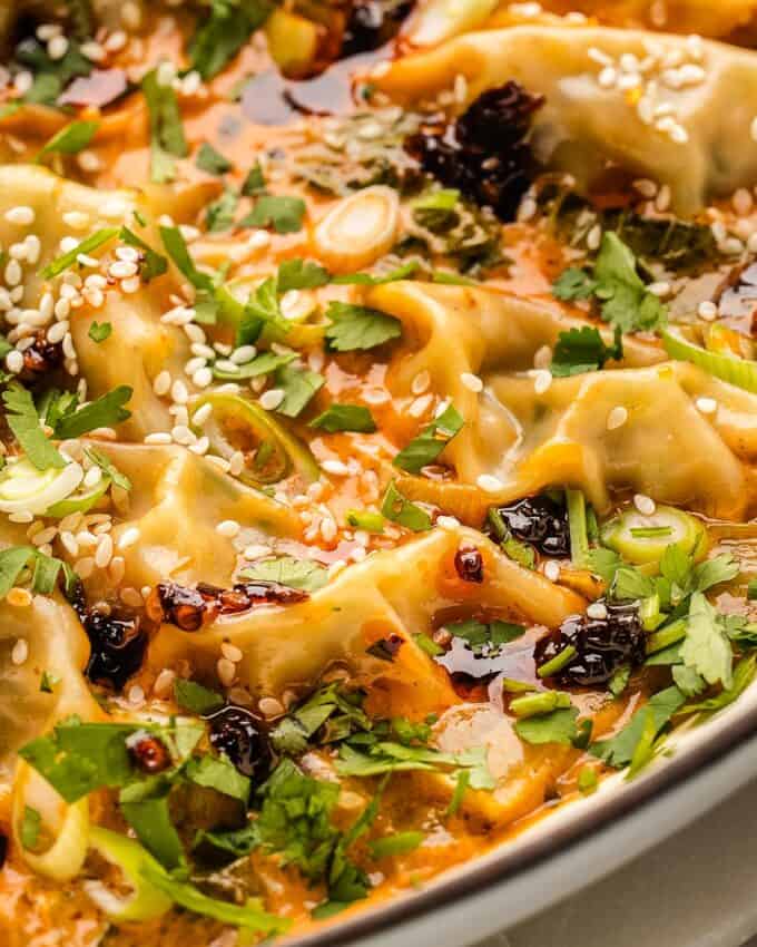 dumpling bake in oven safe skillet topped with chili crisp and greens