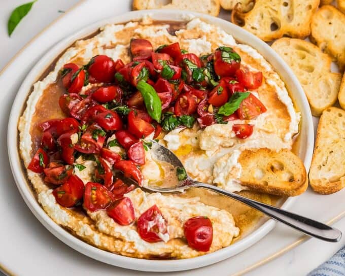 bruschetta dip with whipped feta on a platter with crusty bread