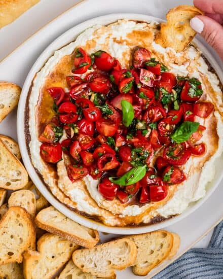 This no-cook bruschetta dip is perfect for summer gatherings or potlucks! It features juicy tomatoes, basil, garlic, balsamic vinegar, all on top of a rich, creamy whipped feta base. Made in minutes, it's great with crusty bread, crackers, and more.