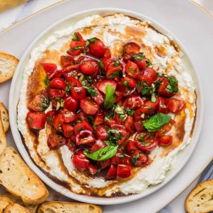 white bowl filled with whipped feta and bruschetta dip