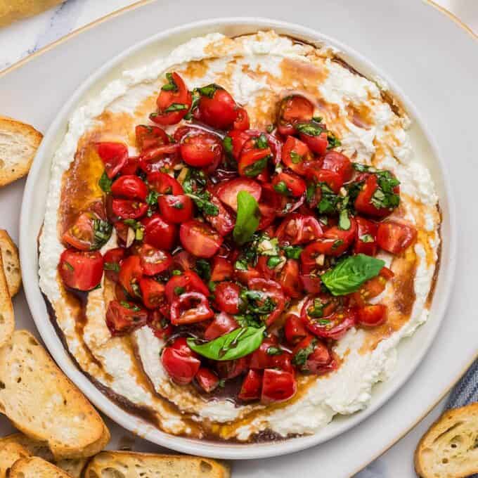 white bowl filled with whipped feta and bruschetta dip