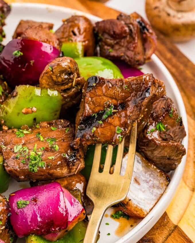 steak skewer disassembled on a plate with a fork