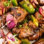 close up view of steak skewers with peppers and onions