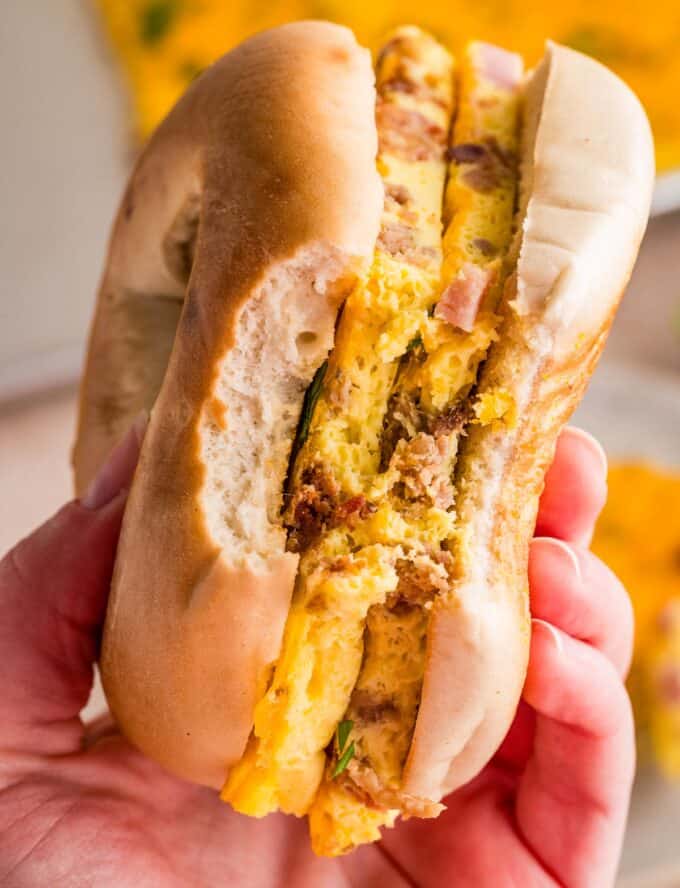 slices of egg scramble on a toasted bagel with a bite taken out of it