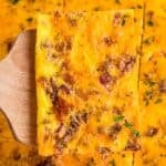 slice of sheet pan egg scramble on a wooden spatula