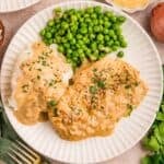 white plate with dijon chicken, peas, and mashed potatoes
