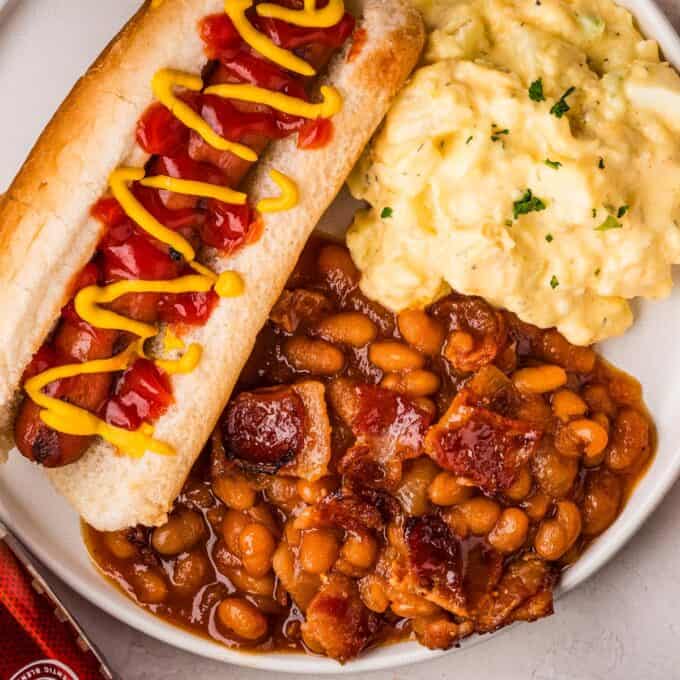 plate with dr pepper baked beans hot dog and potato salad