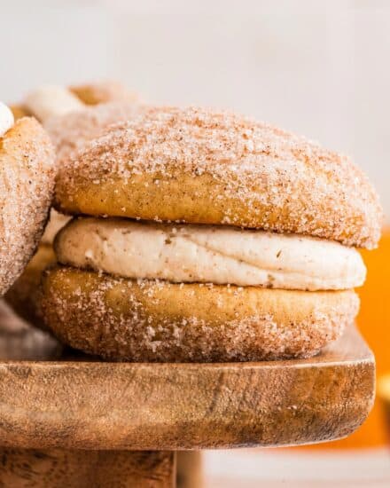 Soft and fluffy apple cider donut cookies are sandwiched together with a browned butter cinnamon buttercream that is bold and luxurious! They’re the perfect Fall baking treat!