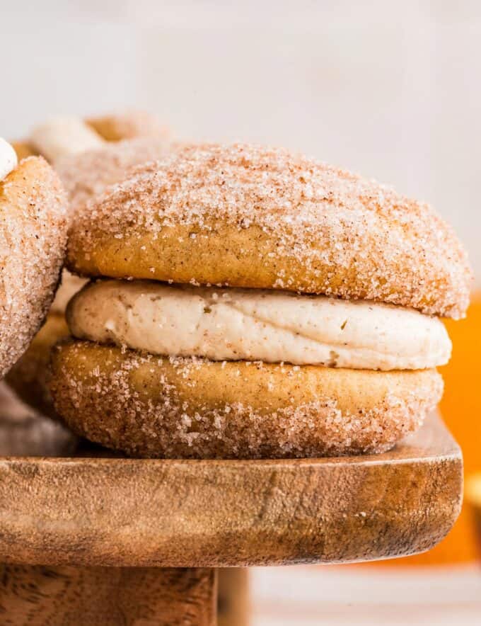 Soft and fluffy apple cider donut cookies are sandwiched together with a browned butter cinnamon buttercream that is bold and luxurious! They’re the perfect Fall baking treat!